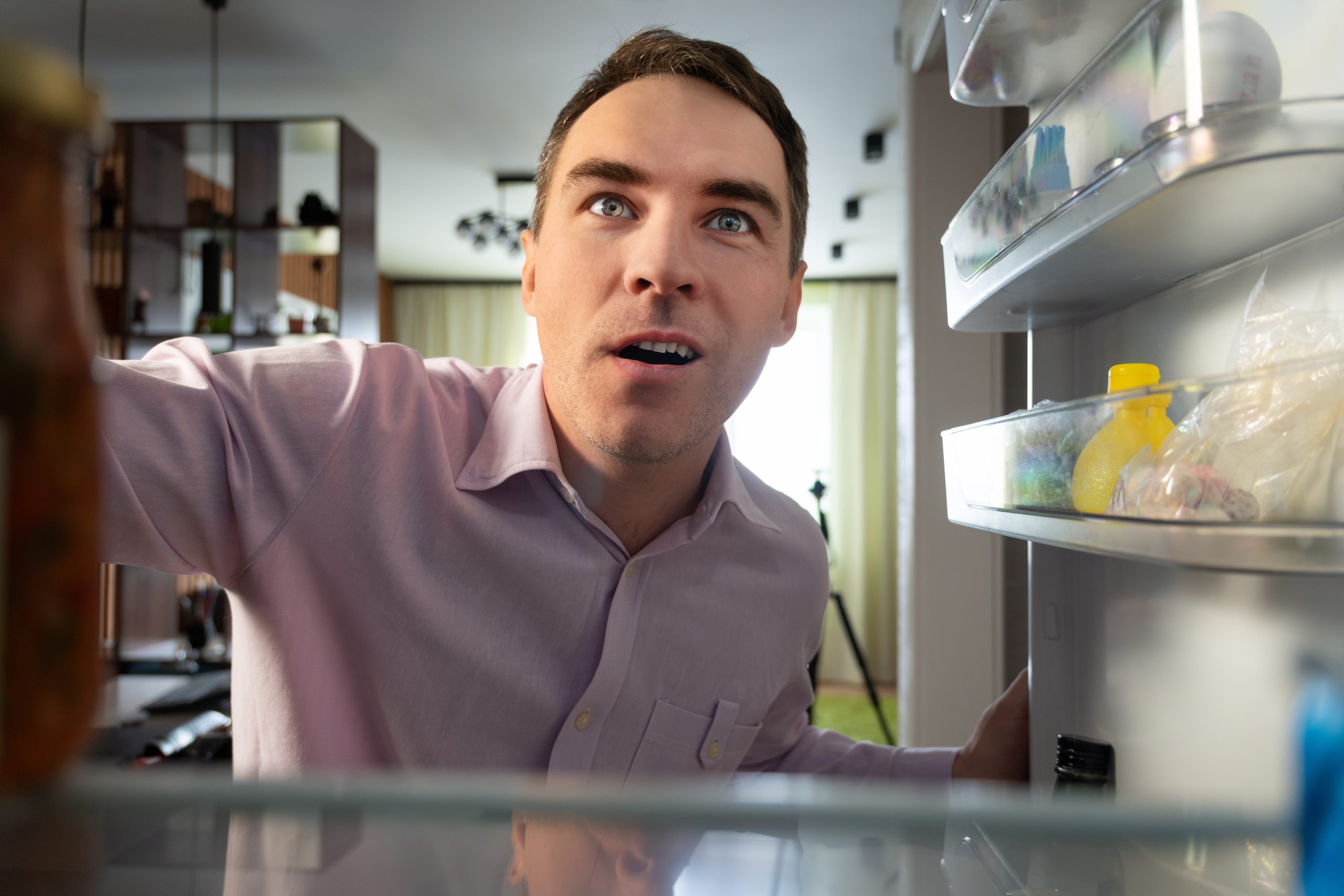 Home owner looking into fridge not cooling